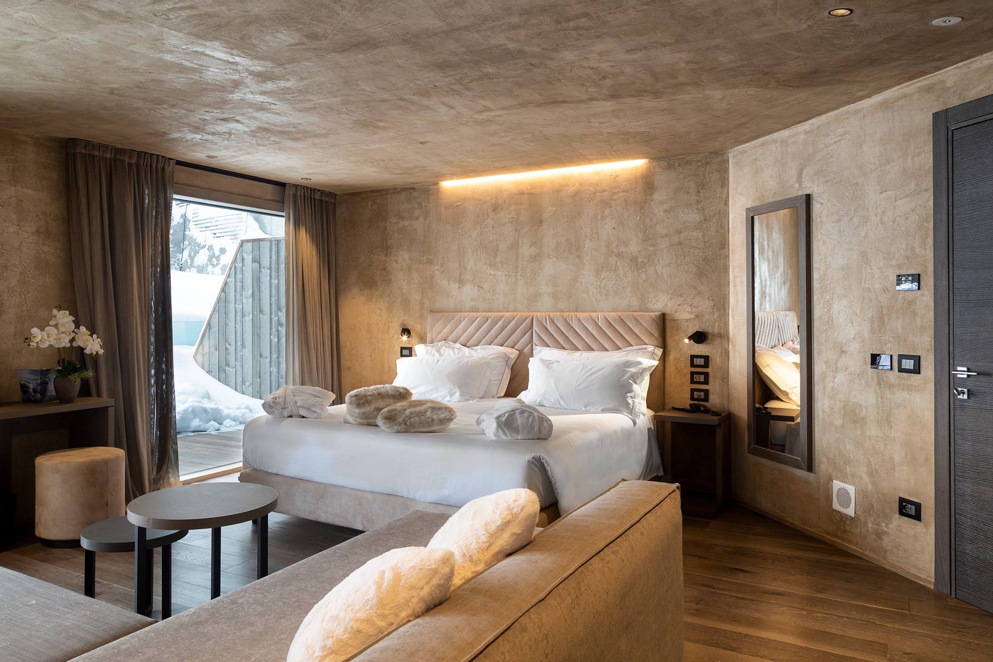 Camera con letto matrimoniale, divano e plaid in pelliccia
