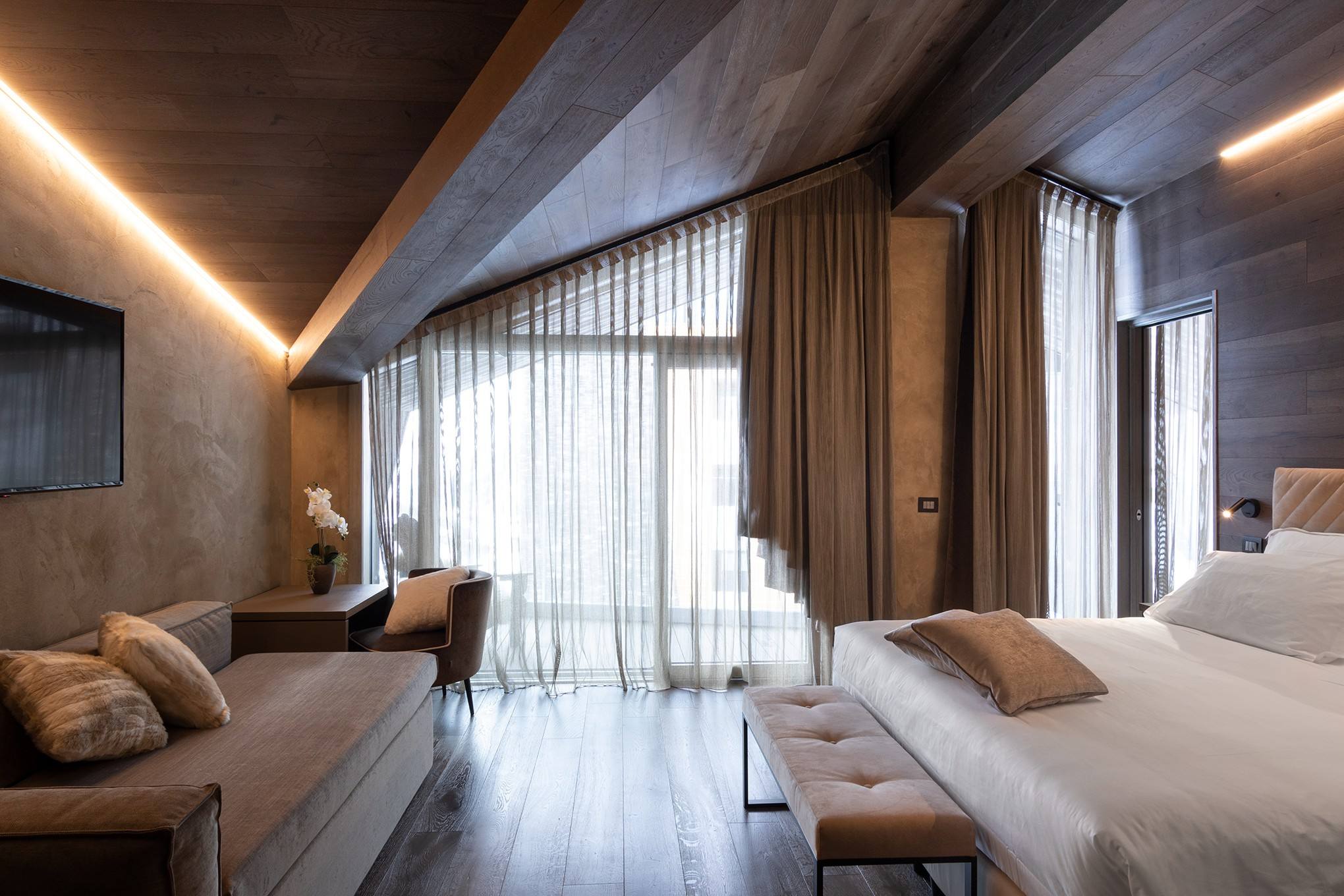 Suite con letto, divano e vetrate