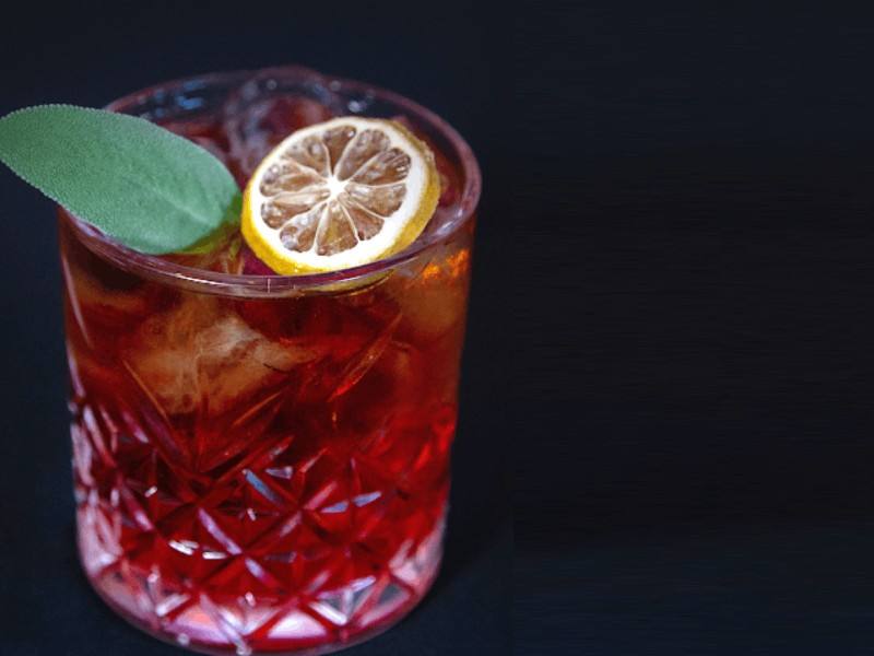 Cocktail rosso con arancia e salvia