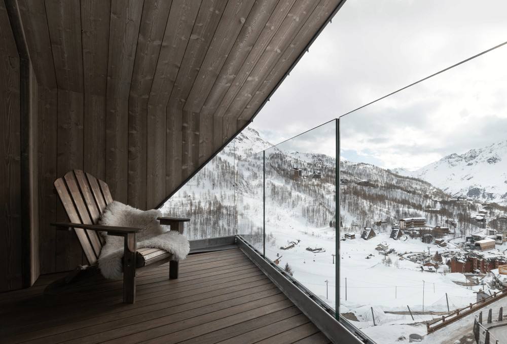 Balcone panoramico della Junior Suite con sedia in legno e neve