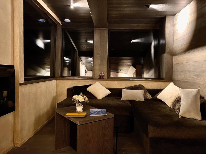 Lounge la sera, con divani e finestre sulla montagna