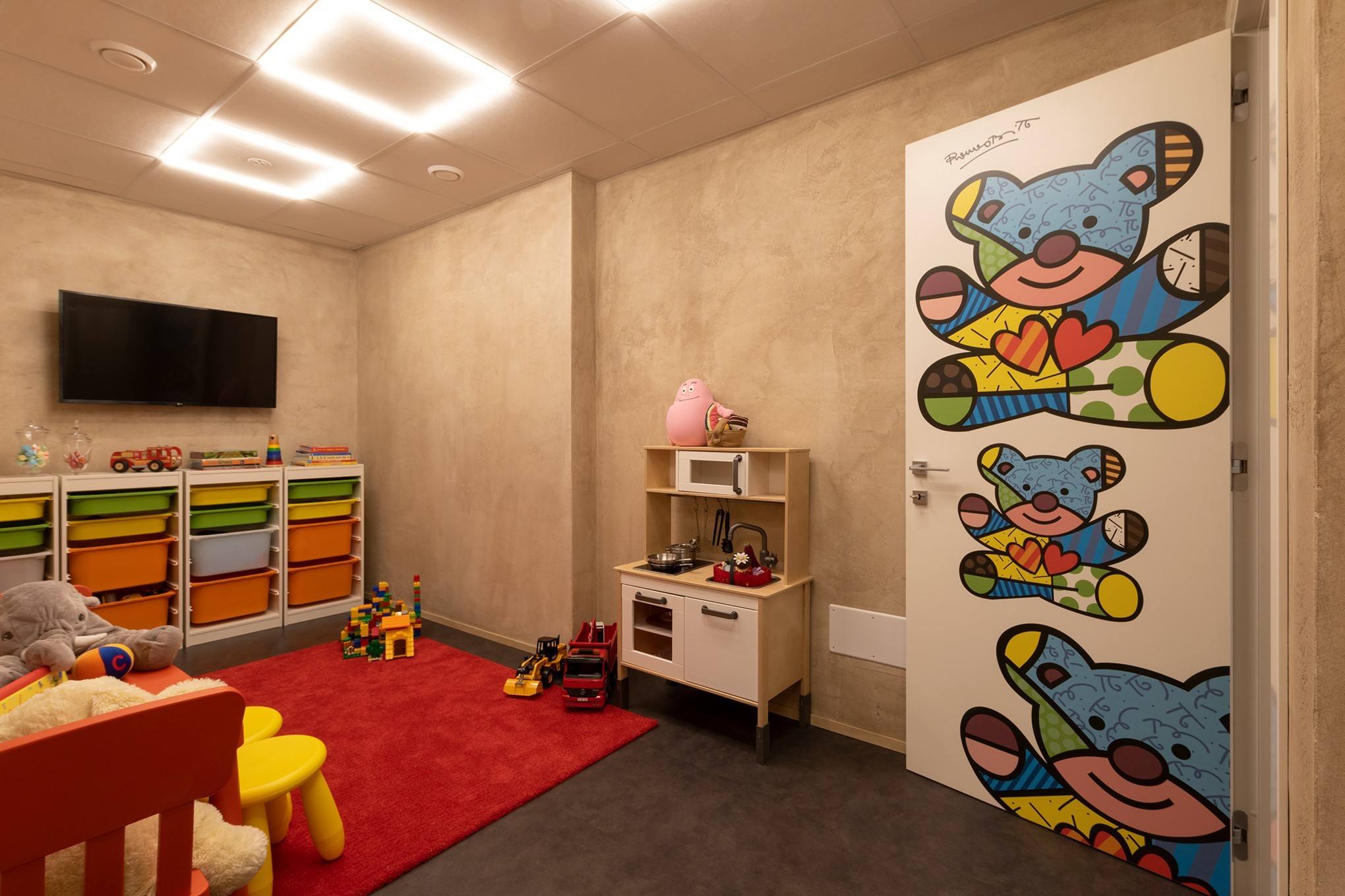 Sala giochi per bambini con tappeto rosso e giocattoli